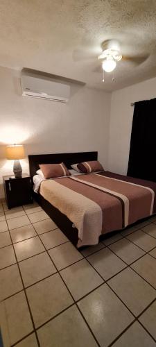 een slaapkamer met een groot bed in een kamer bij VERY SECURED HOUSE 7 MINUTES FROM THE BEACH in Puerto Peñasco
