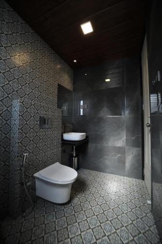 a bathroom with a white toilet and a sink at Privystays Jk's Private Villa in Alibaug