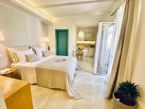 een slaapkamer met een bed en een kamer met een keuken bij Aeolia suites in Karpathos