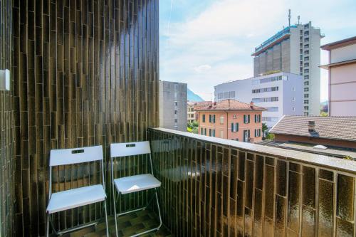 two chairs on the balcony of a building at Palace Apartment by Quokka 360 - 2 minutes from Lugano Lido in Lugano