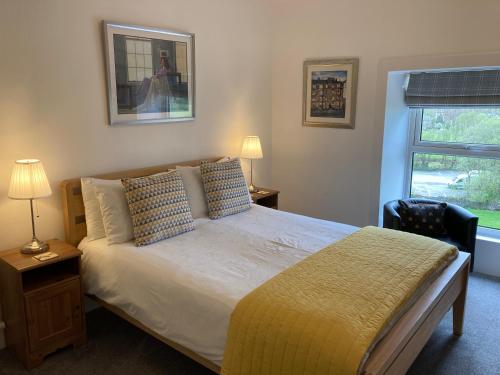 sypialnia z dużym łóżkiem i oknem w obiekcie Ebor House w mieście Hawes