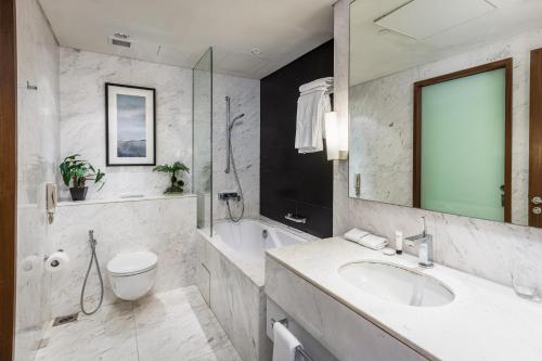 a bathroom with a sink and a toilet and a tub at Kempinski residences-previously The Address Dubai mall in Dubai