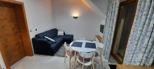 a living room with a table and a couch at ELFF -Apartamenty i pokoje gościnne in Cisna