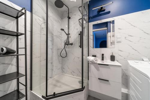 La salle de bains blanche est pourvue d'une douche et d'un lavabo. dans l'établissement Widok z Centrum, à Szklarska Poręba