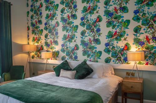 a bedroom with a bed with a green blanket at The Clock Face Prescot in Prescot