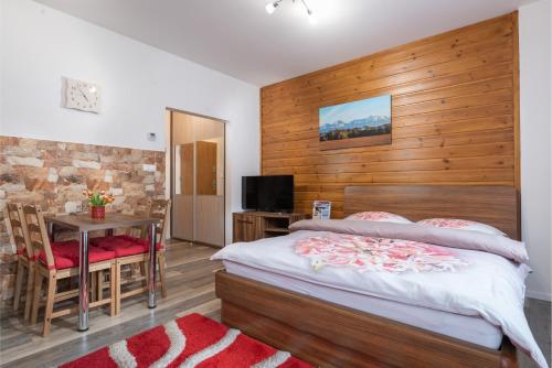 a bedroom with a bed and a table and a television at Tatry Apartman, PRIMO, Starý Smokovec, Vysoké Tatry in Starý Smokovec