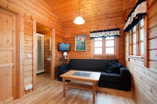 a living room with a couch in a wooden cabin at Nupar Cottages in Ölfus