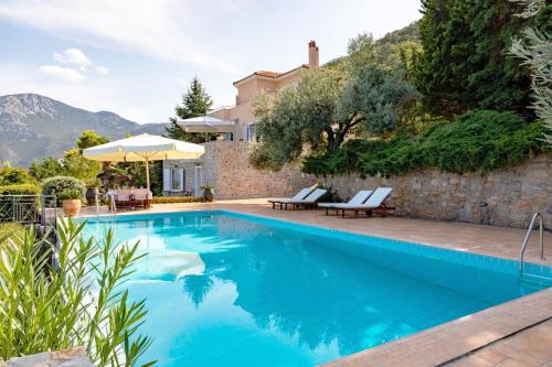 una piscina con 2 sillas y una casa en Epidavros Land villa Elia en Ancient Epidavros