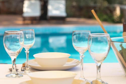 a table with three wine glasses and a bowl at Epidavros Land villa Elia in Ancient Epidavros