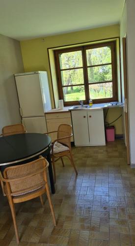 een keuken met een tafel en stoelen en een raam bij Le domaine du bengal 2 in Veuil