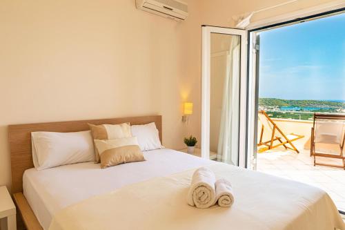a bedroom with a bed with a view of the ocean at Epidavros Land villa Elia in Ancient Epidavros