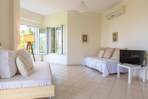 a living room with a couch and a tv at Epidavros Land villa Elia in Ancient Epidavros