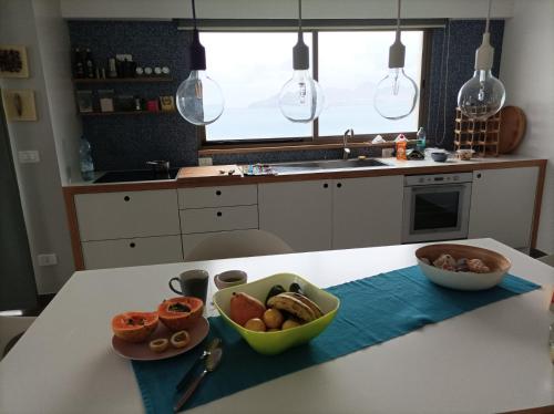 a kitchen with a table with a bowl of food on it at Seafront Holiday House on the Mindelo Bay in Mindelo