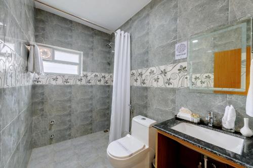 a bathroom with a toilet and a sink and a shower at Click Hotel Guwahati in Guwahati