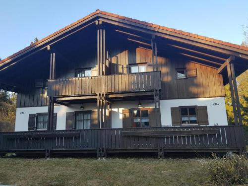 a large wooden house with a large balcony at Ferienhaus MARIA im Waldferiendorf in Regen