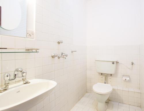 a white bathroom with a toilet and a sink at KATHMANDU NOMAD HOTEL in Kathmandu