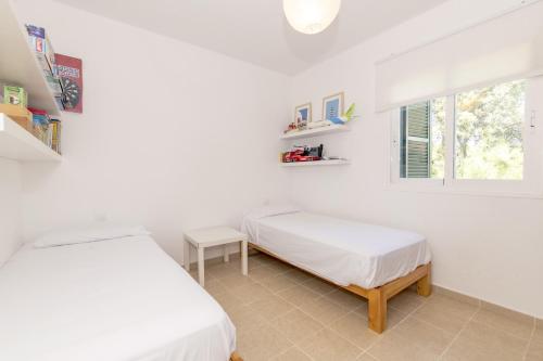 a bedroom with two beds and a window at Biniancolla Ginesta in Biniancolla