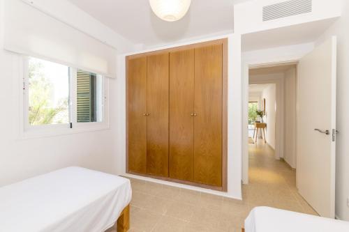 a bedroom with a bed and a wooden cabinet at Biniancolla Ginesta in Biniancolla