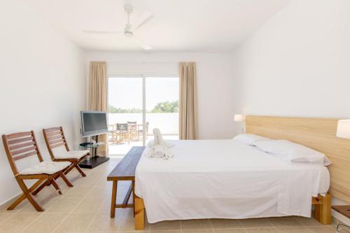 a bedroom with a large white bed and a television at Biniancolla Ginesta in Biniancolla