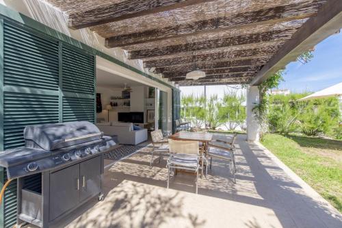 a patio with a grill and a table and chairs at Biniancolla Ginesta in Biniancolla
