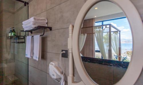 a mirror in a bathroom with a view of the ocean at Blue Sea Hotel in Dali