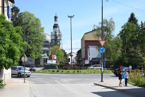 a man and a woman and a child walking down a street at Elem apartmani Skver in Tuzla