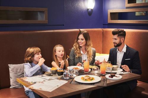 a family sitting at a table in a restaurant at Radisson Blu Sobieski in Warsaw