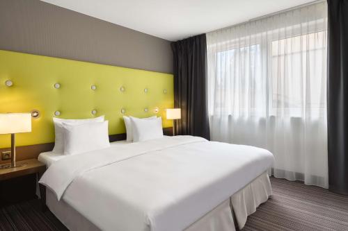 a bedroom with a large white bed and a window at Radisson Blu Sobieski in Warsaw