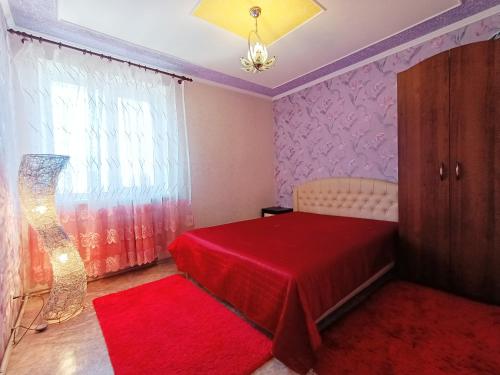 a bedroom with a red bed and a red rug at Шевченко 1 in Kropyvnytskyi
