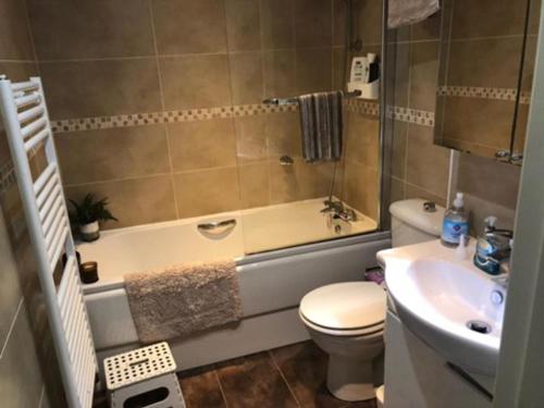 y baño con bañera, aseo y lavamanos. en Captivating Apartment in Copthorne near Gatwick, en Copthorne