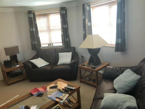a living room with two couches and a table at Captivating Apartment in Copthorne near Gatwick in Copthorne