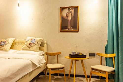 a bedroom with a bed and a table and chairs at Blue Sea Hotel in Dali