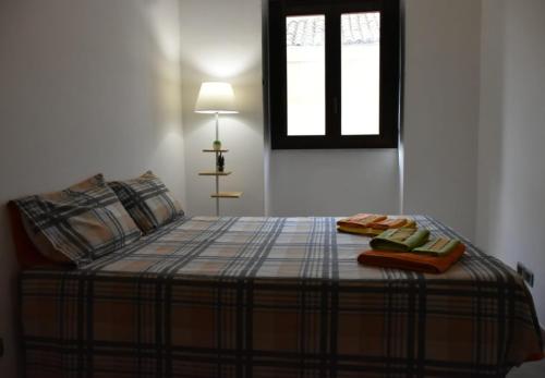 a bed with two towels and a window in a room at Civico 22 in Trapani