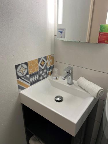 a bathroom with a white sink and a mirror at initial by balladins Tours Sud in Chambray-lès-Tours