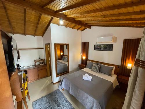 sypialnia z łóżkiem i dużym lustrem w obiekcie Suites Hencke Haus w mieście Canela