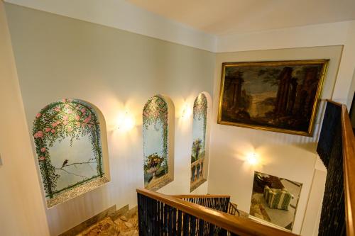 a hallway with three stained glass windows and a staircase at Villa Kinzica in Sale Marasino