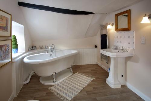 a bathroom with a large tub and a sink at The Old Sweet Shop in Minehead