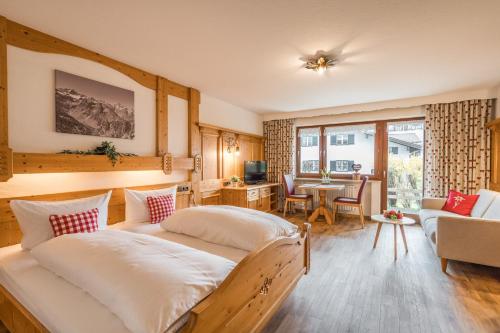 a bedroom with two beds and a living room at Gästehaus Baumgartner in Oberstdorf