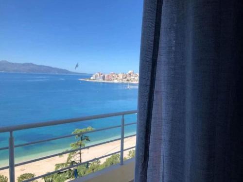 a view of a beach from a window at Genci Seaview Apartaments@AlbaResidence in Sarandë
