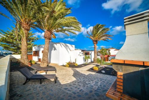 un patio con palmeras y un banco en Casa Tamai, ideal para familias en el centro de la isla en Teguise