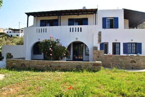 una casa blanca con una planta delante en Andros Studios Tetrafylli en Ándros