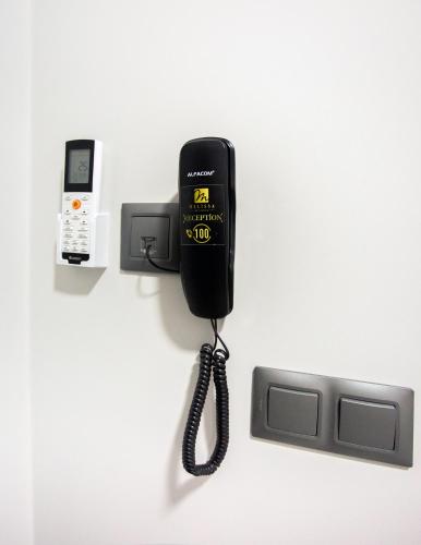 a black phone is attached to a wall at Melissa Suite in Trabzon