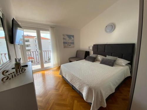 a bedroom with a large bed and a balcony at Apartmani Milkovic in Tučepi