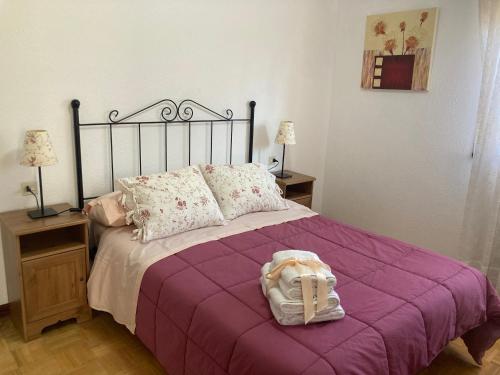 Una cama con una manta púrpura y un bolso. en Apartamento en Colombres, en Colombres