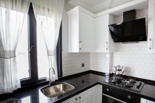 a kitchen with white cabinets and a sink at Melissa Suite in Trabzon