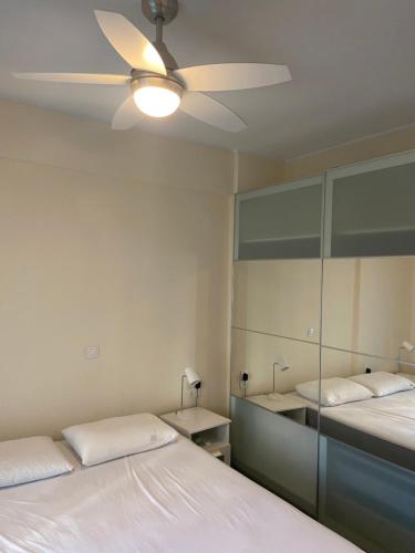 a bedroom with two beds and a ceiling fan at Hercules in Amaliápoli