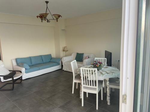 a living room with a table and a blue couch at Hercules in Amaliápoli