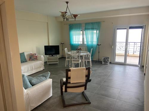 a living room with a couch and a table with a tv at Hercules in Amaliápoli