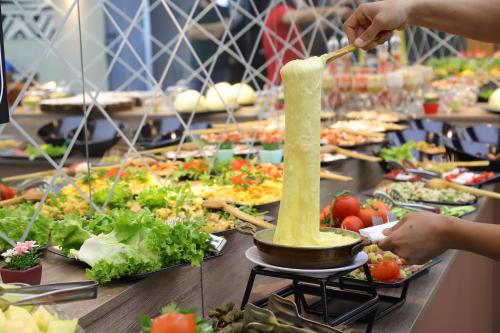 una linea di buffet di cibo con persone che preparano il cibo di SWEET HOME SUiTE HOTEL a Trabzon