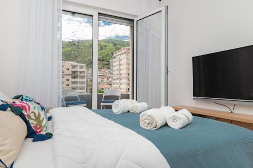 a bedroom with a bed with a flat screen tv at Central One-Bedroom Apartment in Budva